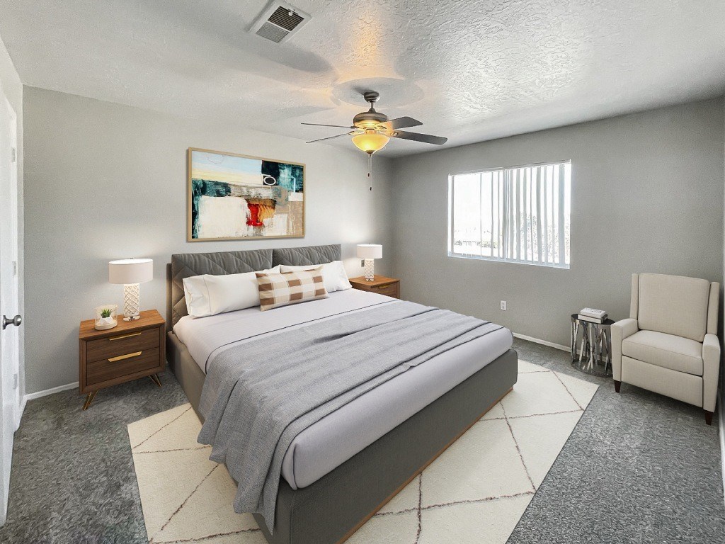 A bedroom with a large bed and a ceiling fan.